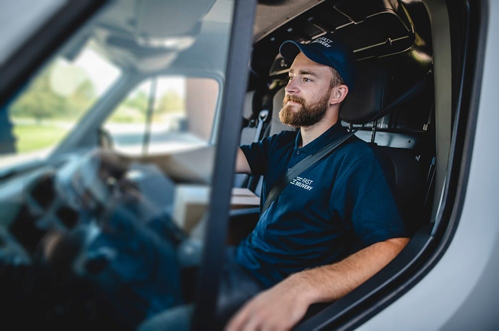 View of a man smiling while driving a delivery truck