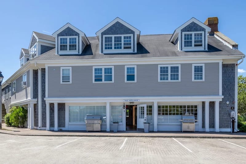 The Yale Appliance Nantucket storefront, a gray cedar-shingled building with white trim and dormers, grills displayed along the covered front porch, and a Yale Appliance sign over the entrance