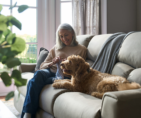 Labor Day Sale - Woman sitting on a couch with her dog