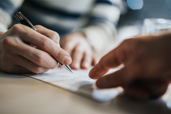 a customer signing paperwork with a black pen