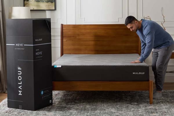 A man setting up a new bed