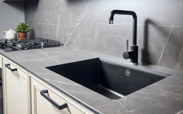 Front view of a black marble luxury kitchen sink in a modern kitchen.