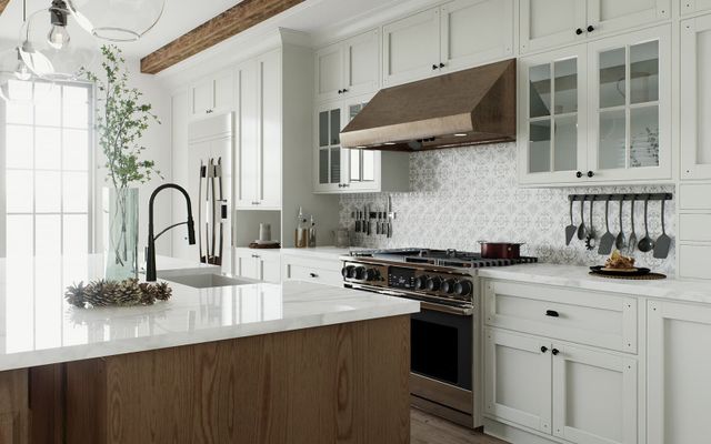View of a modern kitchen with white walls and cabinetry, a gas range, and a luxury kitchen sink in an island.