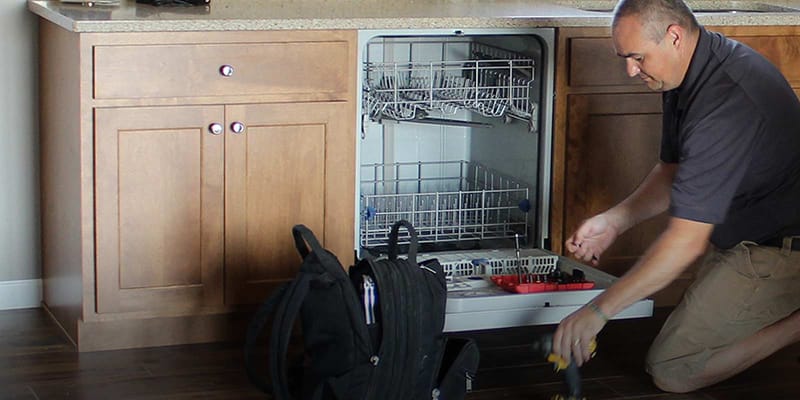 Village Home Stores technician repairing a dishwasher