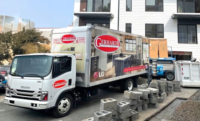 View of a Gerhard's Appliances truck delivering appliances to a new apartment building.