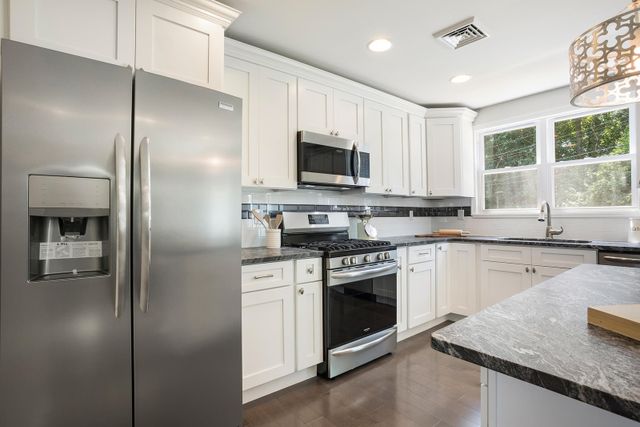 View of a modern kitchen with white cabinetry and a builder appliance package from Gerhard's Appliances