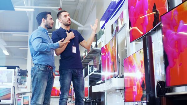 Salesperson with a client on an electronics showroom